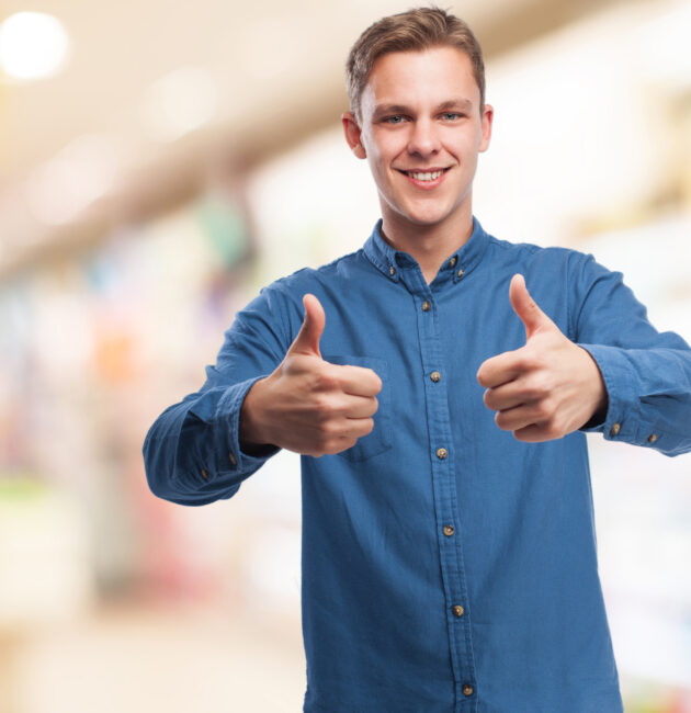 homem branco, cabelos loiros, camisa social da cor azul, levantando os polegares em sinal de aprovação / satisfação dos clientes